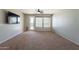 Bright living room with carpet and large windows, offering a comfortable and inviting space at 18003 W Carmen Dr, Surprise, AZ 85388