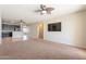 Spacious living room with ceiling fan is open to the kitchen, creating a seamless entertaining space at 18003 W Carmen Dr, Surprise, AZ 85388