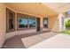Covered patio with multiple windows, security door, and outdoor seating area, extending the living space at 18003 W Carmen Dr, Surprise, AZ 85388