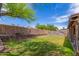 Lush backyard featuring a tiered block wall, lawn, and mature trees on a sunny day at 18016 N 145Th Ave, Surprise, AZ 85374