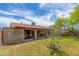 Backyard view featuring covered patio, lawn, trees, and a block wall for privacy at 18016 N 145Th Ave, Surprise, AZ 85374