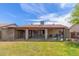 Spacious backyard featuring a covered patio with furniture, lawn, and block perimeter wall at 18016 N 145Th Ave, Surprise, AZ 85374