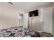 Cozy bedroom with neutral walls, TV, and colorful quilt; has access to another room at 18016 N 145Th Ave, Surprise, AZ 85374