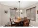 Dining room with dark wood table, four chairs, and natural lighting through blinds at 18016 N 145Th Ave, Surprise, AZ 85374