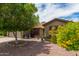 Single-story home with desert landscaping, mature tree, and well-maintained exterior at 18016 N 145Th Ave, Surprise, AZ 85374