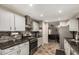Updated kitchen with modern stainless steel appliances and tiled backsplash, adjacent to a cozy living area at 18016 N 145Th Ave, Surprise, AZ 85374