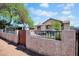 Charming single-story home with a secure decorative wall, appealing landscaping, and a bright blue sky at 1815 E Illini St, Phoenix, AZ 85040