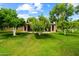 Expansive backyard with lush green lawn, mature trees and the back exterior of a single-story home at 19053 N Lakeforest Dr, Sun City, AZ 85373