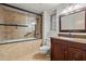 Bathroom with a large glass-enclosed shower, granite countertop vanity and tile flooring at 19053 N Lakeforest Dr, Sun City, AZ 85373