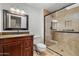Bathroom with glass enclosed shower, granite countertops, and wood cabinets at 19053 N Lakeforest Dr, Sun City, AZ 85373