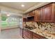 Kitchen with stainless steel appliances, wooden cabinets, granite countertops, and adjacent breakfast area with backyard views at 19053 N Lakeforest Dr, Sun City, AZ 85373