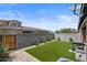 Green backyard with a well-maintained artificial lawn, privacy fence, and desert landscaping at 1906 N 140Th Dr, Goodyear, AZ 85395