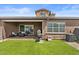 Spacious backyard with an artificial lawn, a covered patio, and ample space for outdoor enjoyment at 1906 N 140Th Dr, Goodyear, AZ 85395
