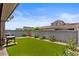 Picturesque backyard showcasing a lush artificial lawn, tasteful landscaping, and privacy fence at 1906 N 140Th Dr, Goodyear, AZ 85395