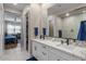 Bright bathroom featuring double sinks, undermount cabinet storage and a tiled walk-in shower at 1906 N 140Th Dr, Goodyear, AZ 85395
