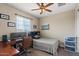 Bedroom with a large window, desk, and ceiling fan at 1906 N 140Th Dr, Goodyear, AZ 85395