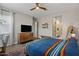 This bedroom features a large bed, lots of light, a ceiling fan and a dresser at 1906 N 140Th Dr, Goodyear, AZ 85395