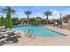 Resort-style community pool surrounded by palm trees, lounge chairs, and well-maintained landscaping at 1906 N 140Th Dr, Goodyear, AZ 85395