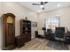 This home office has a dark wood bookcase, light walls and a ceiling fan at 1906 N 140Th Dr, Goodyear, AZ 85395