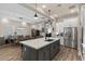 Open-concept kitchen with a large island, stainless steel appliances, and a dining area at 1906 N 140Th Dr, Goodyear, AZ 85395