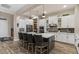 Well-lit kitchen featuring white cabinets, stainless steel appliances, and a spacious island with bar seating at 1906 N 140Th Dr, Goodyear, AZ 85395
