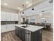 Modern kitchen with a large island, white cabinetry, stainless appliances, and open layout to the living area at 1906 N 140Th Dr, Goodyear, AZ 85395