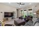 Spacious living room with a large TV, leather furniture, and access to the backyard at 1906 N 140Th Dr, Goodyear, AZ 85395