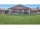 Expansive backyard with a covered patio, seating, and lush green lawn at 19215 N Concho Cir, Sun City, AZ 85373