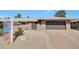 Charming home with brick driveway, two-car garage, gated entryway, and desert landscaping in the front yard at 19215 N Concho Cir, Sun City, AZ 85373