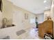 Functional laundry room with a sink, tiled backsplash, closet, and work desk at 19215 N Concho Cir, Sun City, AZ 85373