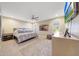 Bright main bedroom with a ceiling fan, neutral walls, carpet, and two windows at 19215 N Concho Cir, Sun City, AZ 85373