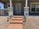 Inviting front porch with classic columns, secure door, and manicured gravel landscaping, with steps to the front door at 201 S Greenfield S Rd # 222, Mesa, AZ 85206