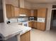 Well-lit kitchen with updated appliances, wooden cabinets, tile flooring, and a breakfast bar at 201 S Greenfield S Rd # 222, Mesa, AZ 85206