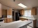 Kitchen featuring wooden cabinetry, skylight, black refrigerator, and breakfast bar with tile countertop at 201 S Greenfield S Rd # 222, Mesa, AZ 85206