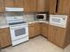 Kitchen area showcases wooden cabinets, tile countertops, and modern white appliances at 201 S Greenfield S Rd # 222, Mesa, AZ 85206