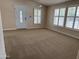 Bright living room featuring neutral carpet, white trim, plantation shutters, and a stylish entry door at 201 S Greenfield S Rd # 222, Mesa, AZ 85206