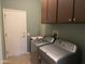 Spacious laundry room with modern washer and dryer, storage cabinets, and a convenient sink at 20376 N Coronado Way, Surprise, AZ 85374