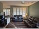 Inviting living room with comfortable leather sofas, ceiling fan, and shuttered windows offering ample sunlight at 20376 N Coronado Way, Surprise, AZ 85374