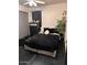 A bedroom with a black bed set and decor and a natural potted plant at 21570 N Greenway Rd, Maricopa, AZ 85138