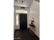 Elegant entryway with modern light fixture, stylish console table, and dark tile flooring at 21570 N Greenway Rd, Maricopa, AZ 85138