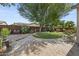 Landscaped backyard with trees, grass, brick pavers, retaining wall, and planters at 2226 W Periwinkle Way, Chandler, AZ 85248