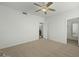 Neutral bedroom with ceiling fan, carpet, white walls, and an open door leading to the hall at 2226 W Periwinkle Way, Chandler, AZ 85248