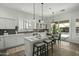 Bright kitchen features a center island with pendant lights, tiled floors, white cabinetry, and stainless steel appliances at 2226 W Periwinkle Way, Chandler, AZ 85248