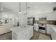 Open concept kitchen with a center island, stainless steel appliances, and seamless flow to living area at 2226 W Periwinkle Way, Chandler, AZ 85248