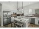 Bright kitchen featuring stainless appliances, a center island with seating, and sleek white countertops and cabinetry at 2226 W Periwinkle Way, Chandler, AZ 85248