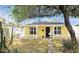 Charming yellow home featuring a covered front porch, well-kept yard, and mature tree at 227 N Morris --, Mesa, AZ 85201
