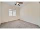 Standard bedroom with neutral carpeting, ceiling fan, and window overlooking neighborhood at 23139 E Via Del Sol --, Queen Creek, AZ 85142