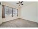 Bright bedroom with plush carpeting, ceiling fan, and a large window offering plenty of natural light at 23139 E Via Del Sol --, Queen Creek, AZ 85142