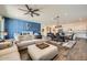 Bright, open-concept living space with a modern ceiling fan, stylish furniture, and wood-look tile flooring at 23139 E Via Del Sol --, Queen Creek, AZ 85142