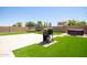 Backyard featuring a grill, hot tub, artificial grass, and privacy wall at 291 E Canyon Rock Rd, San Tan Valley, AZ 85143